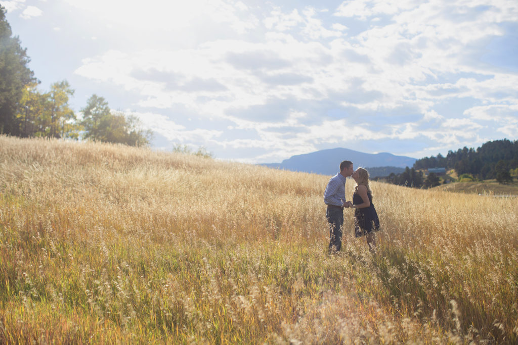Colorado engagement photos in a grassy field 