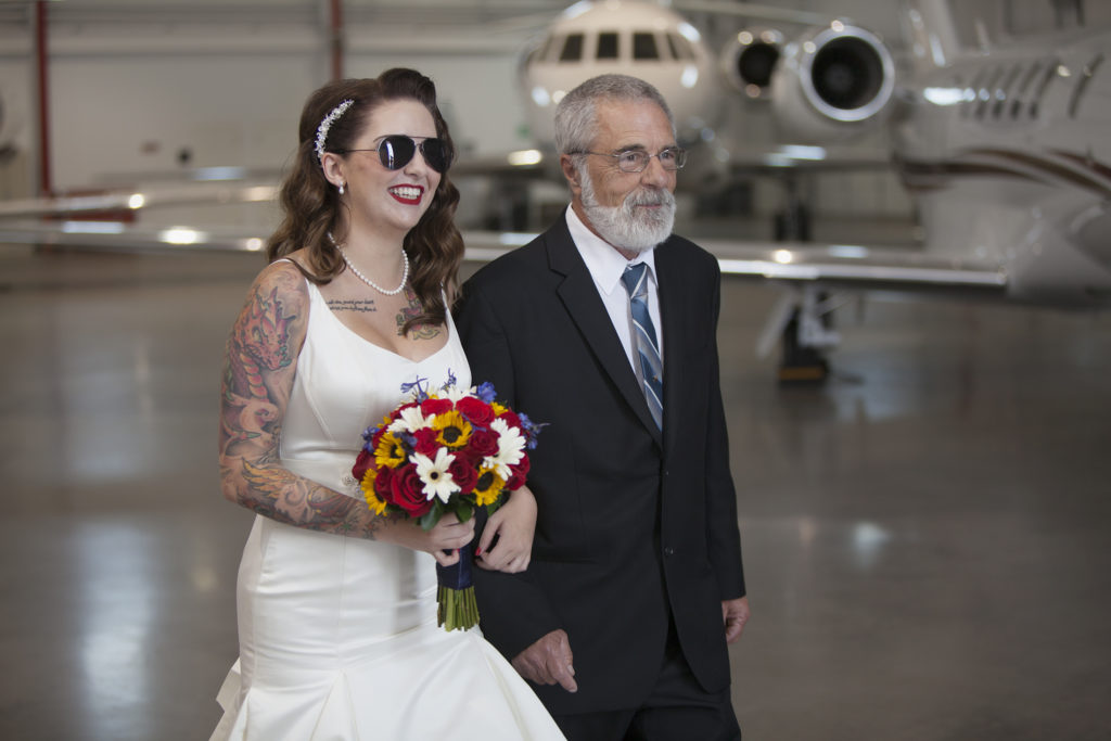 Bride walks down the aisle in Centennial airport hangar