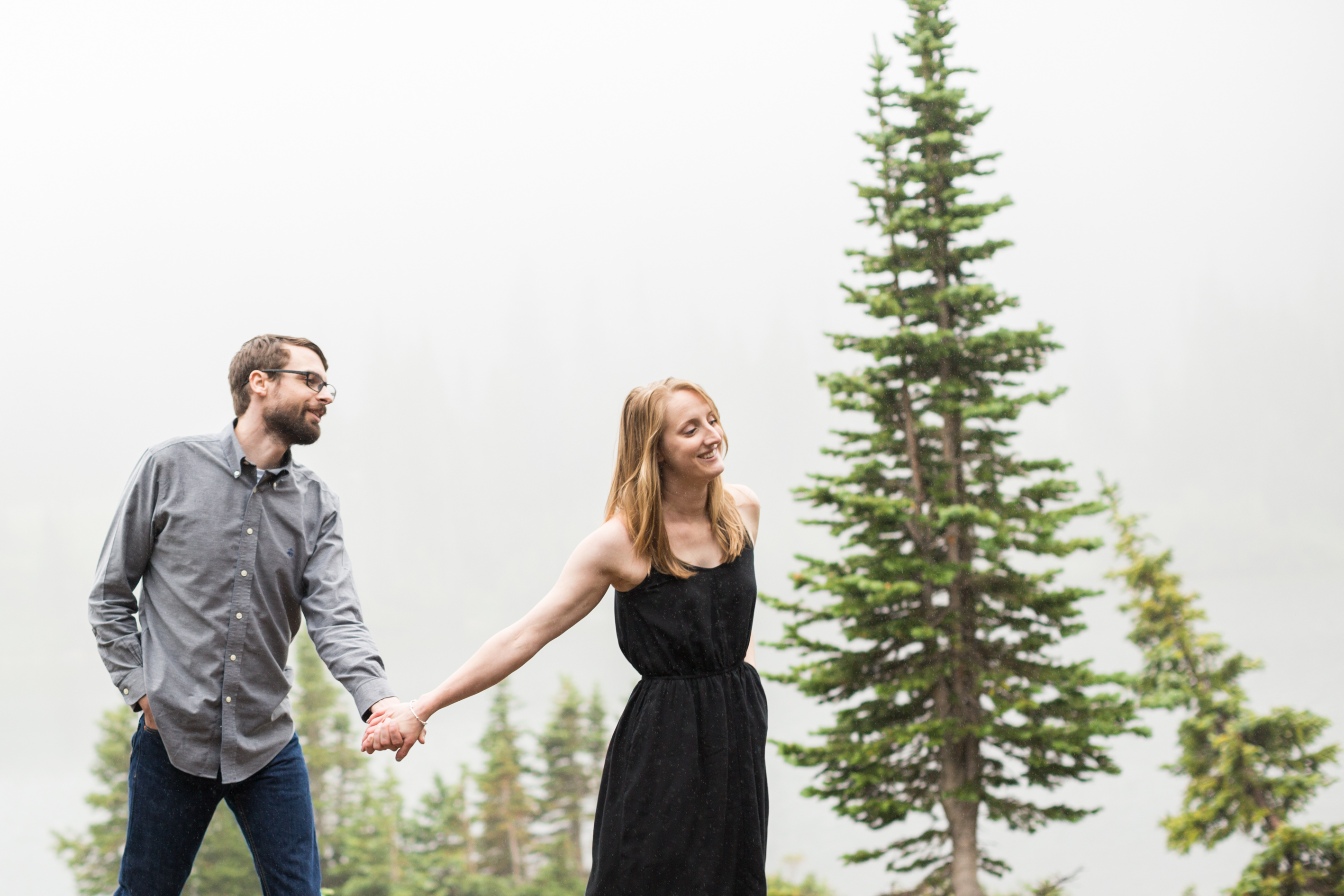 Brainard Lake engagement photos at Long Lake bride and groom walk holding hands in the fog
