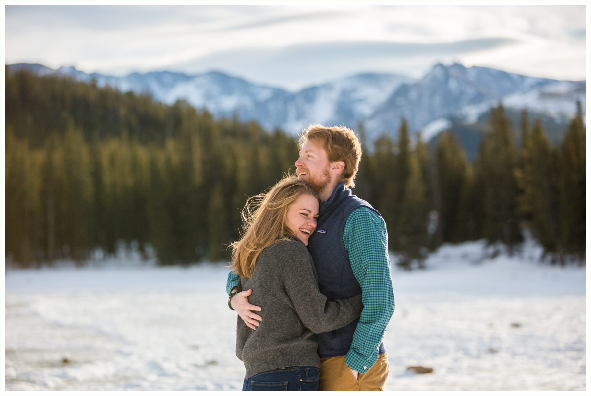 Echo Lake Park winter engagement session in the Colorado mountains. Colorado mountain wedding photographer. Colorado engagement photographer. natural candid Colorado engagement photography. Outdoor winter engagement photos in Colorado mountains. Colorado mountain wedding photographer. grey top and button down with outdoorsy vest winter engagement outfits