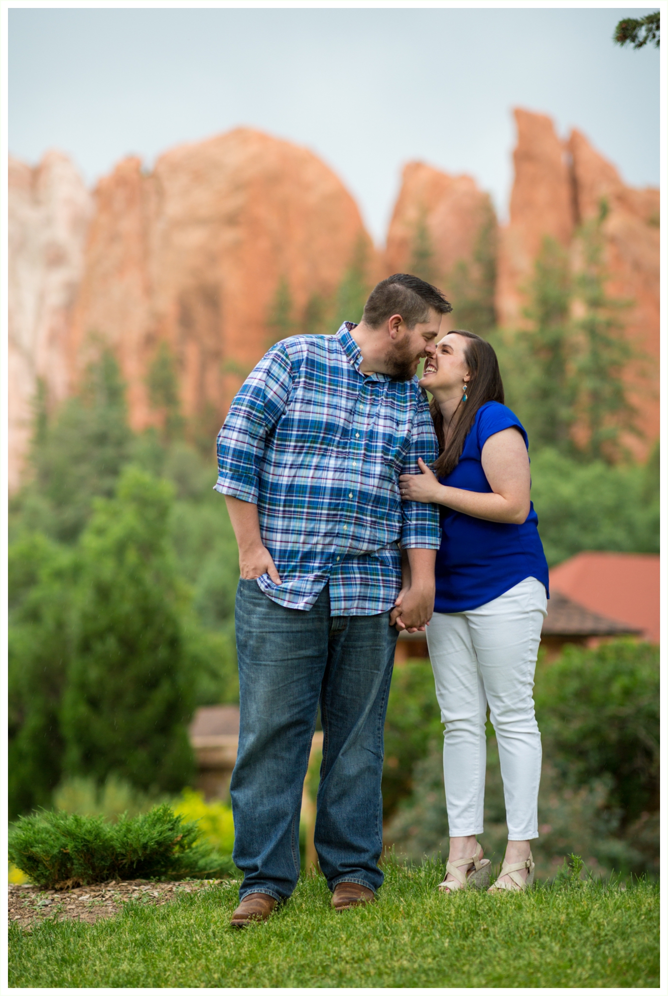 sweetest couple for colorado springs engagement session at glen eyrie castle. views of garden of the gods rock formations in background. 