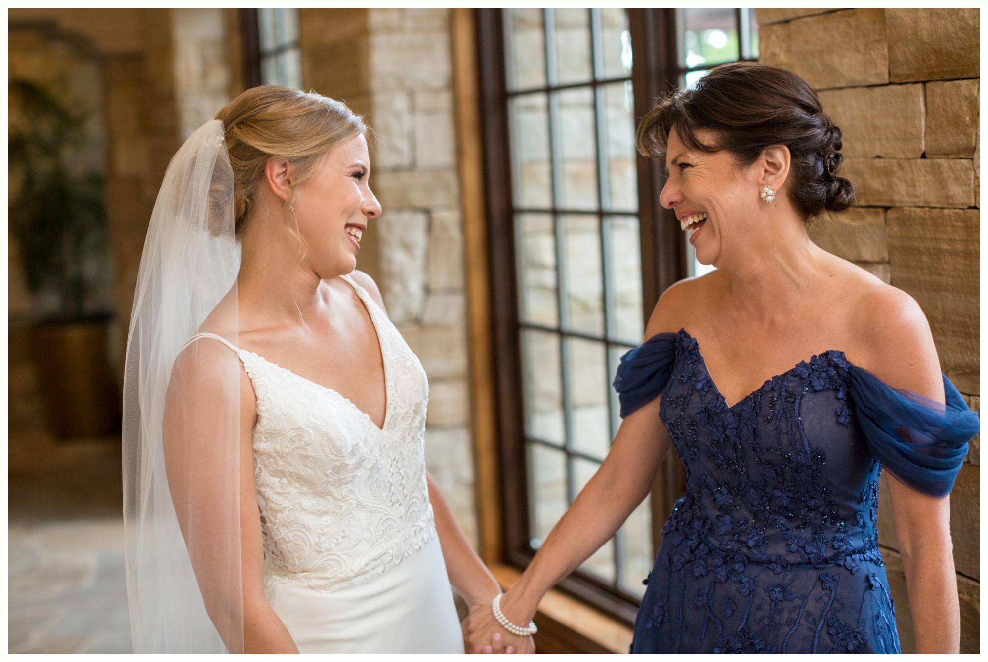 bride and her mom sharing sweet moments while bride gets into wedding dress