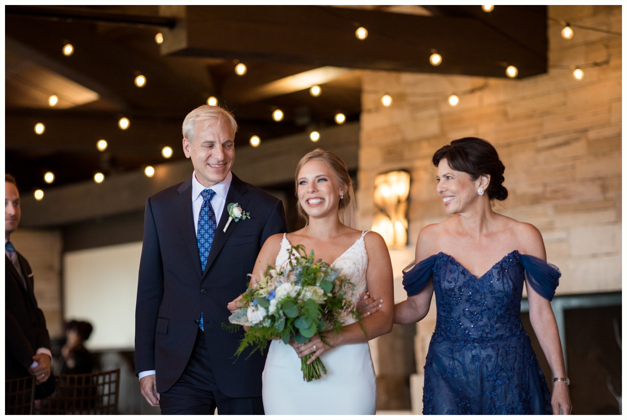 bride walks down the aisle with her mom and dad during jewish wedding ceremony