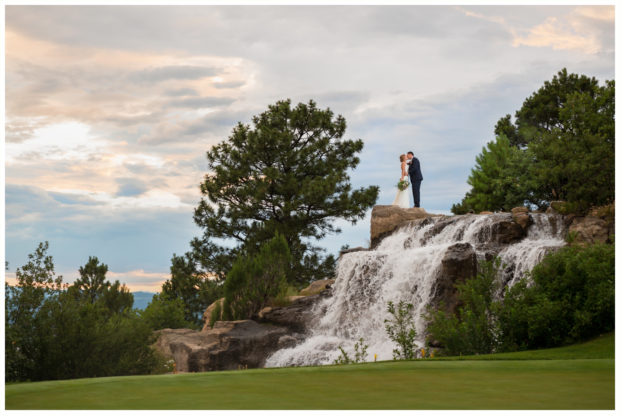 bride and groom sunset portraits on top of waterfall at sanctuary golf course wedding in colorado