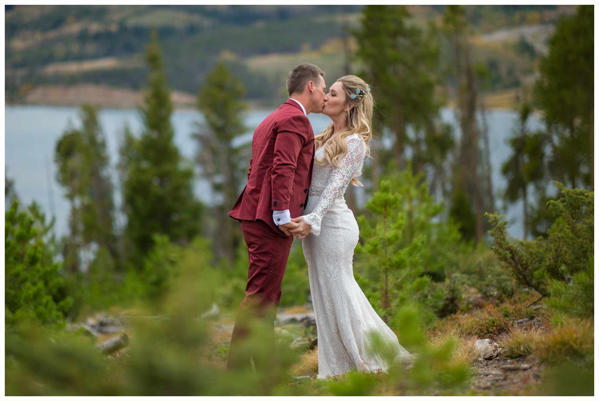 fashionable bride groom portraits at sapphire point groom wears maroon suit bride long sleeved lace dress kissing