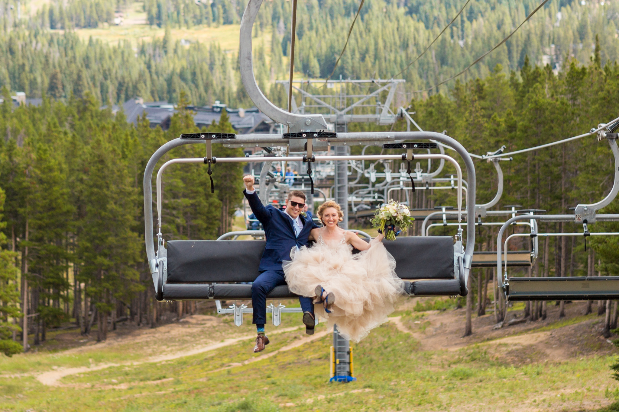 fun wedding portrait of bride and groom on ski lift in breckenridge colorado captured by colorado mountain wedding photographer 